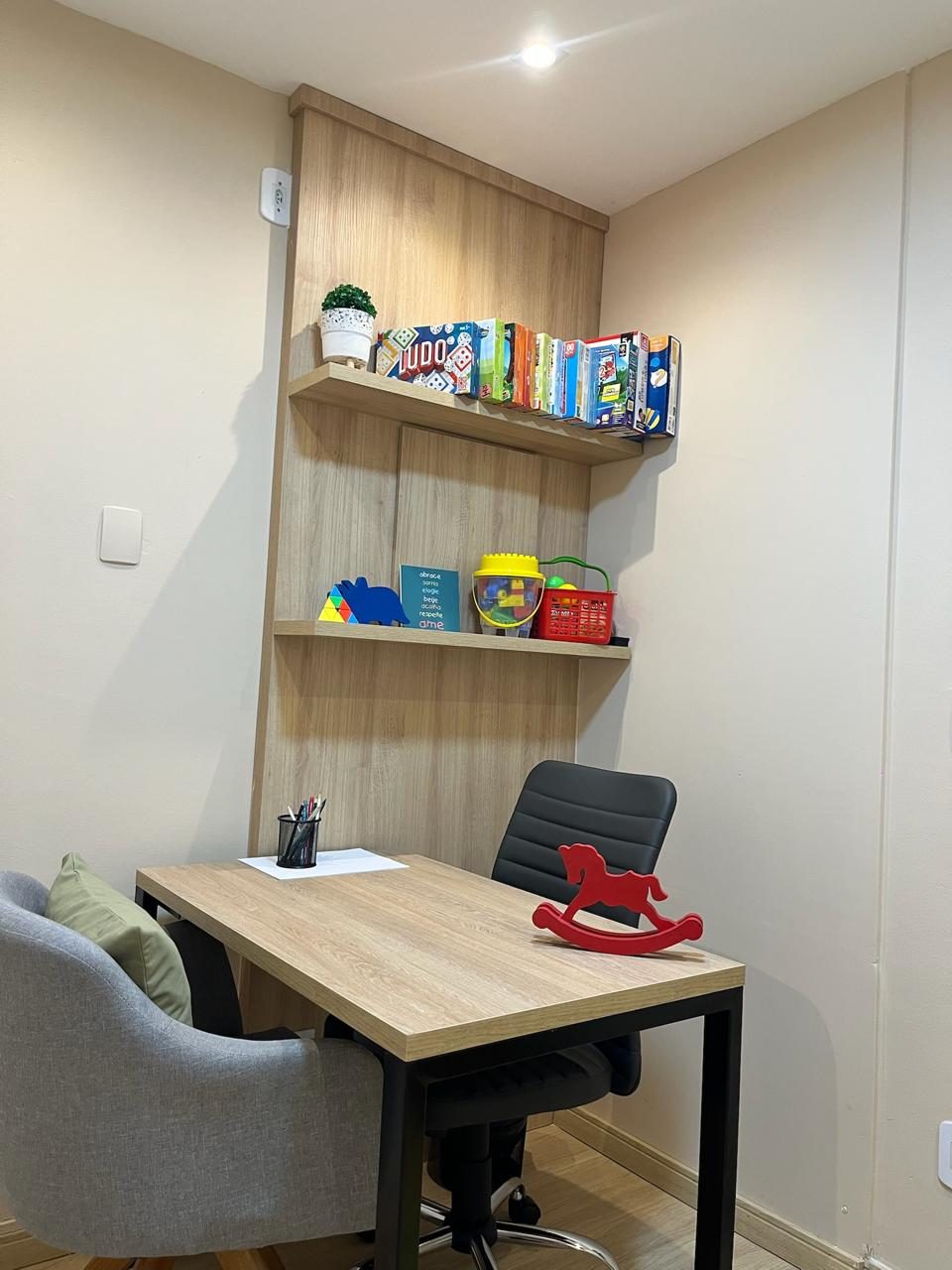 Sala com mesa de atendimento e estante de jogos