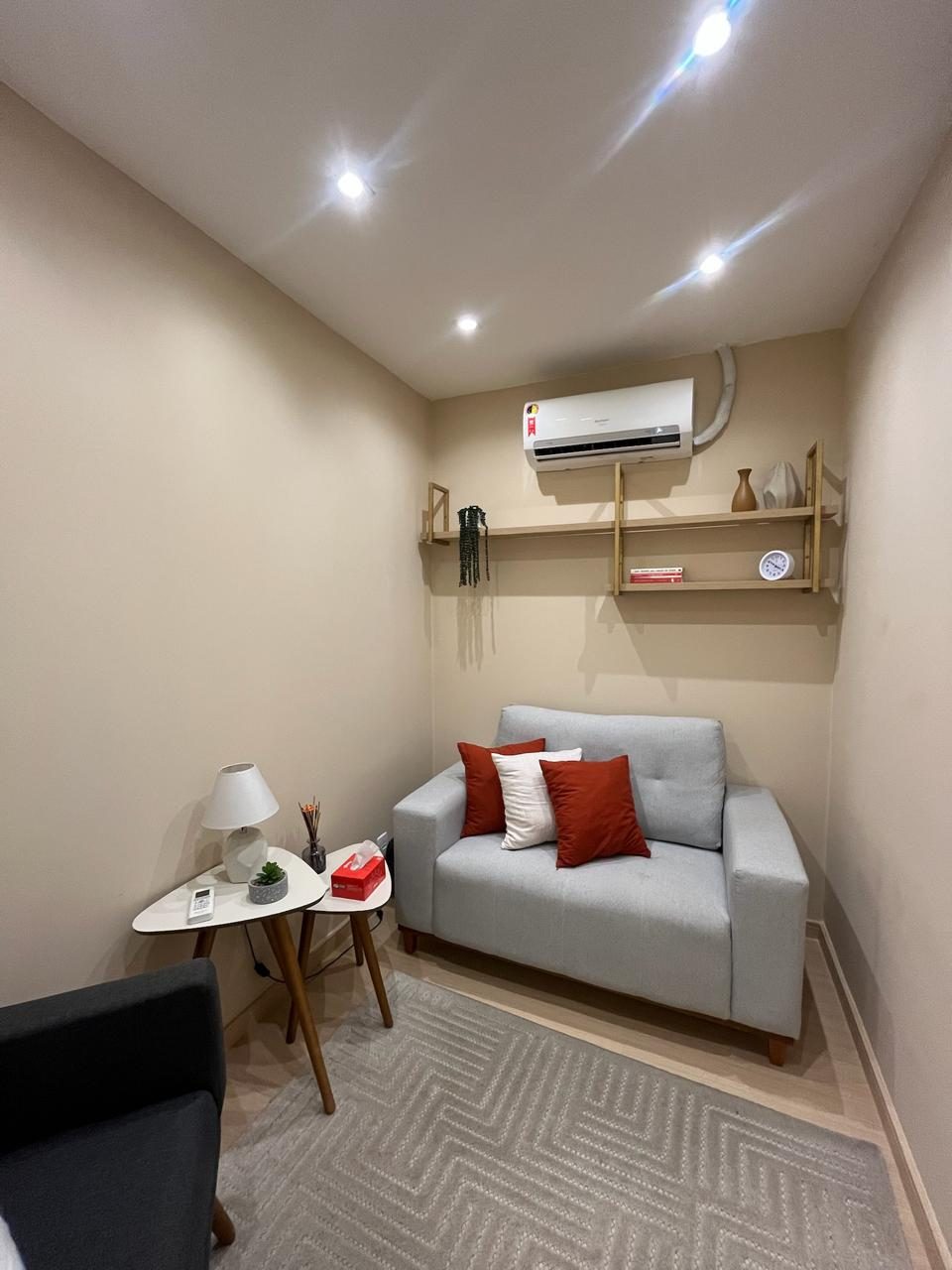 Sala de atendimento com sofá e almofadas